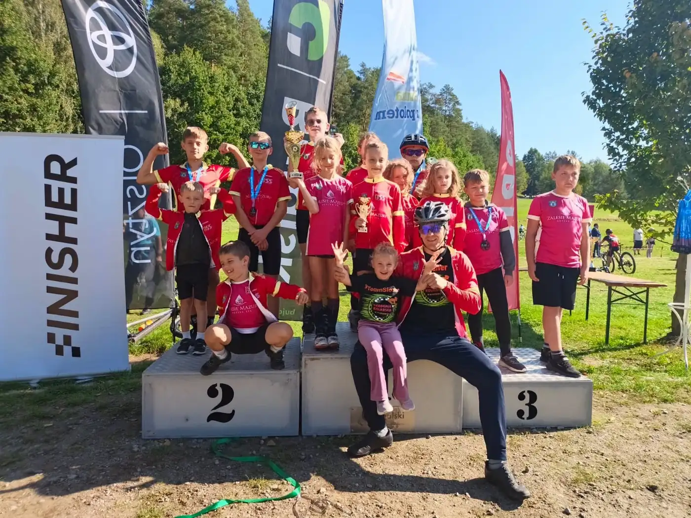 Zawodnicy Akademii Kolarskiej w Barczewie z trenerem na podium zawodów MTB